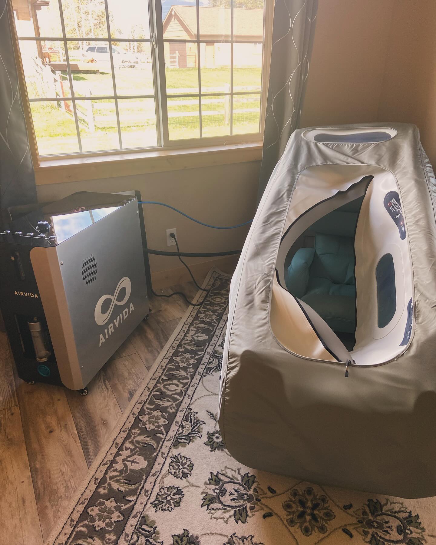 Air purifier and air quality monitor on a wooden floor with a window in the background