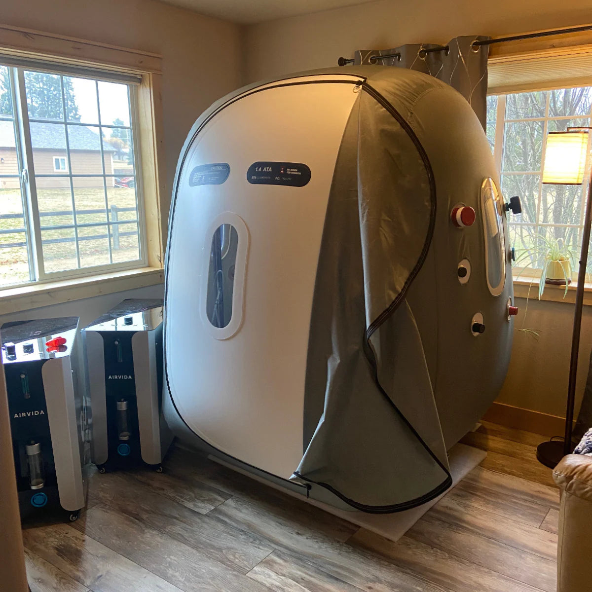 Oxygen therapy chamber in a room with windows and equipment.