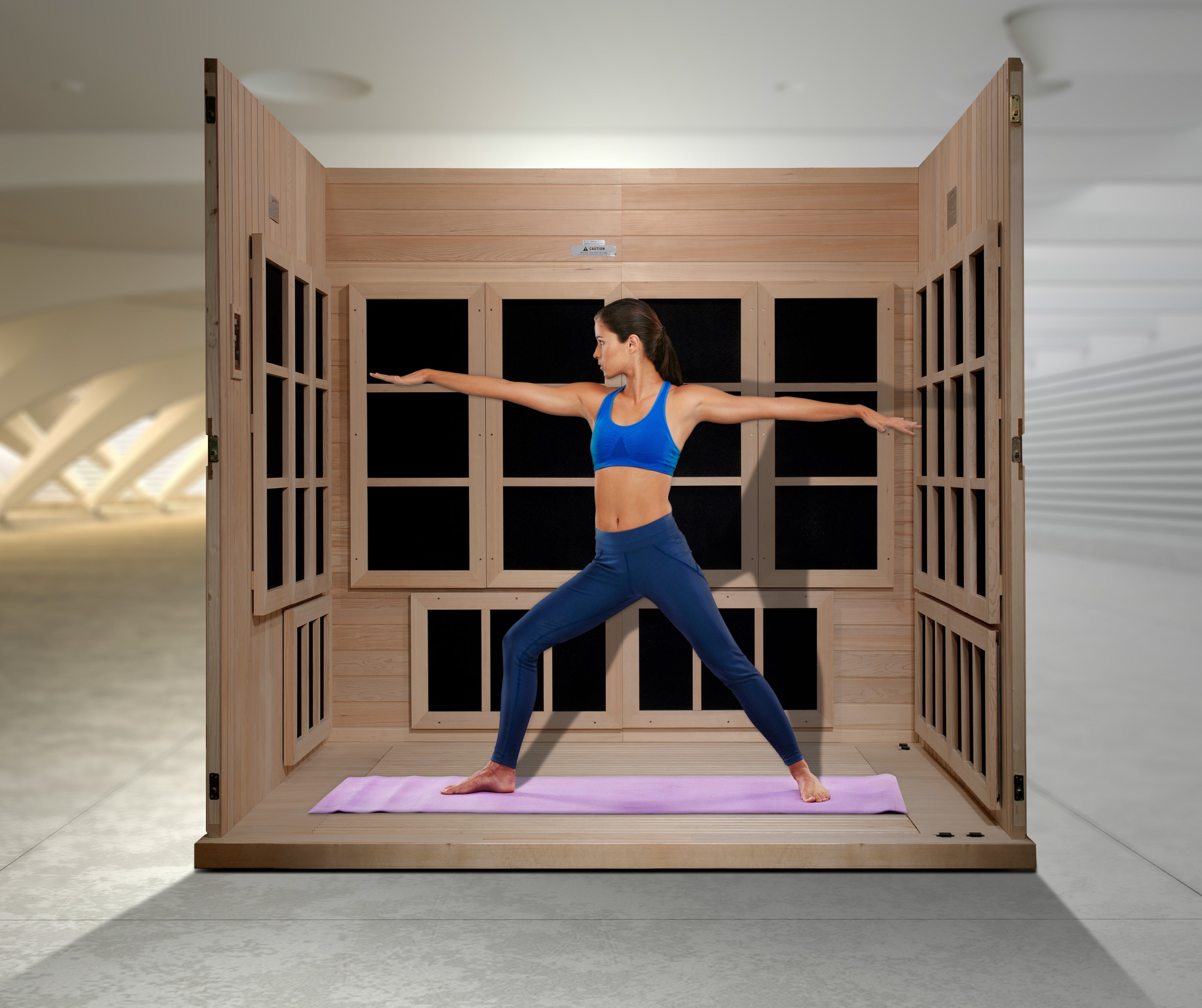 Woman practicing yoga in a wooden infrared sauna