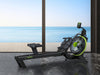 Rowing machine with M360 branding in a room with large windows showing a beach view.