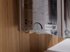 Metallic wall-mounted device with label and QR code on a wooden surface