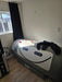 Gray and white hyperbaric chamber in front of a window in a white room on a wooden floor