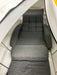 Gray cushioned chair inside a hyperbaric chamber with a white interior.