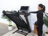 Woman interacting with a treadmill in a home setting