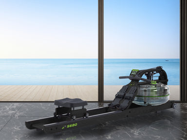 Rowing machine on a marble floor with a large window view of the ocean.