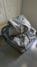 Sitting hyperbaric chamber deflated in a gray room on a wooden floor with accessory units attached