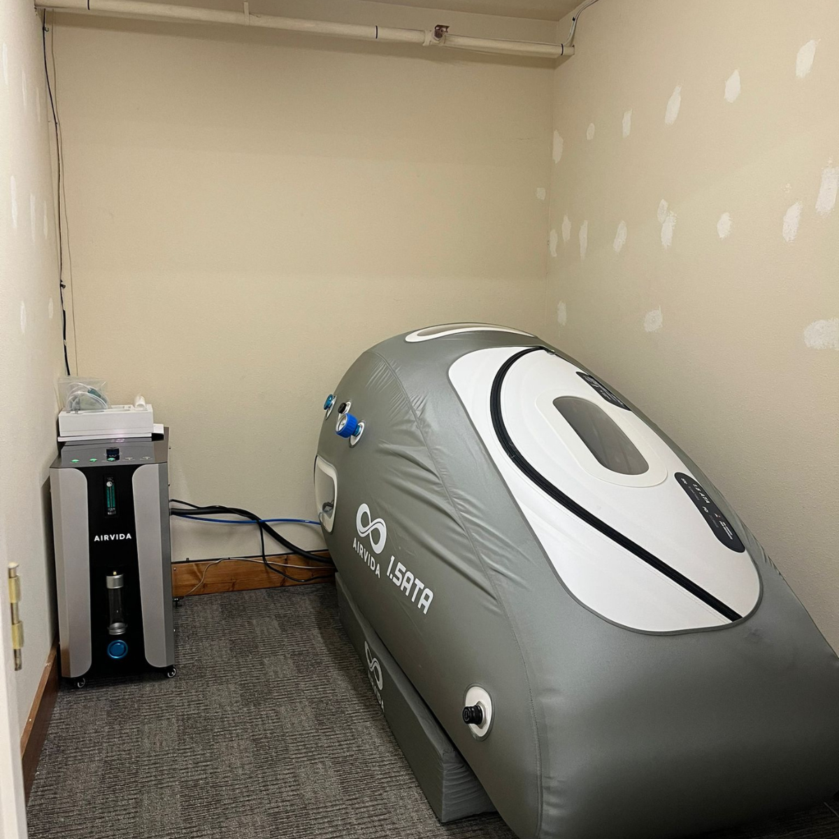 Hyperbaric chamber with 'AIRVIA' branding on a carpeted floor.