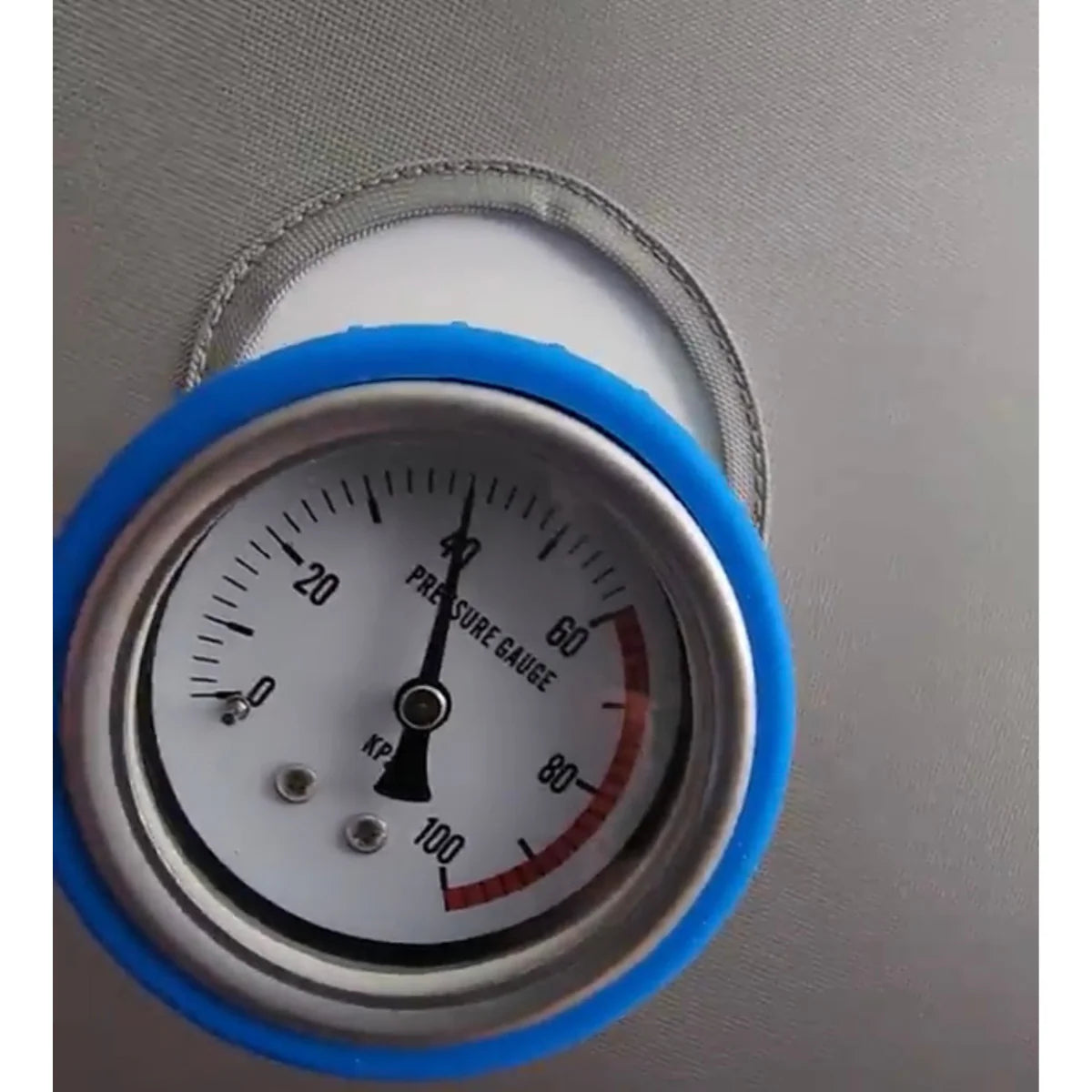 Pressure gauge with blue rim on a metallic surface