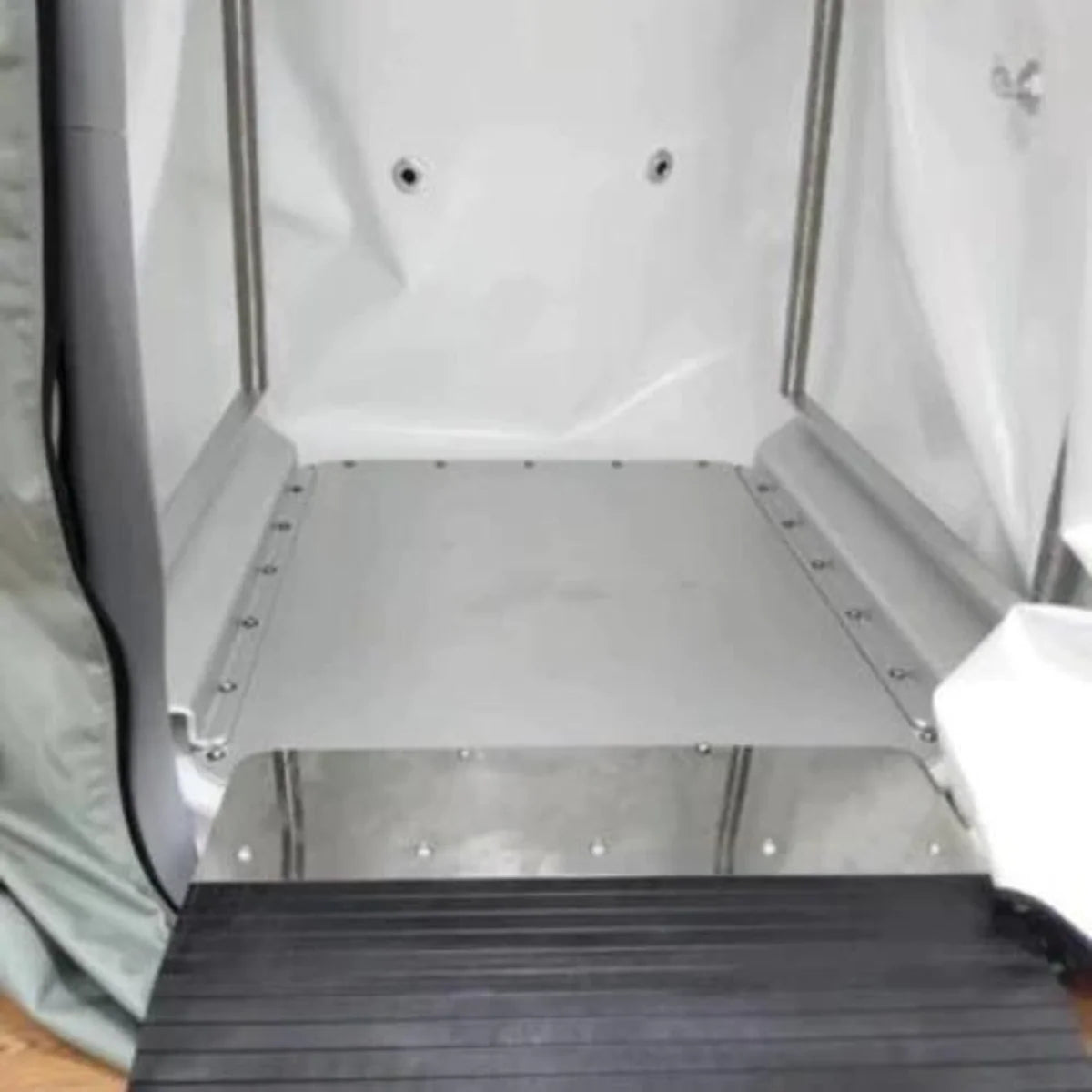 Inside of a Sitting hyperbaric chamber with a gray floor and a black wheelchair ramp
