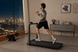 Man running on a treadmill in a room with a cityscape view